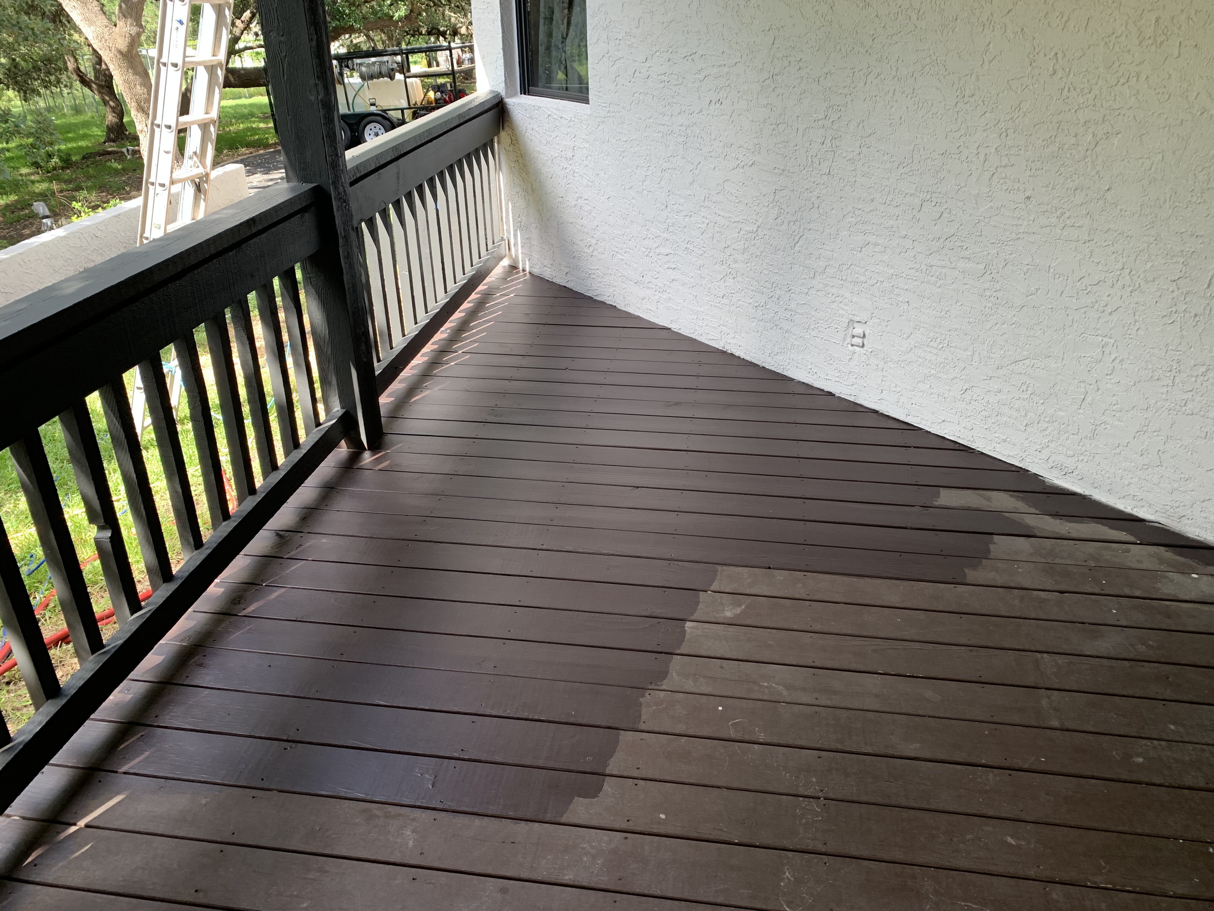 Another angle of the deck before cleaning — mixed sections of raw wood and remaining paint that had failed over the years