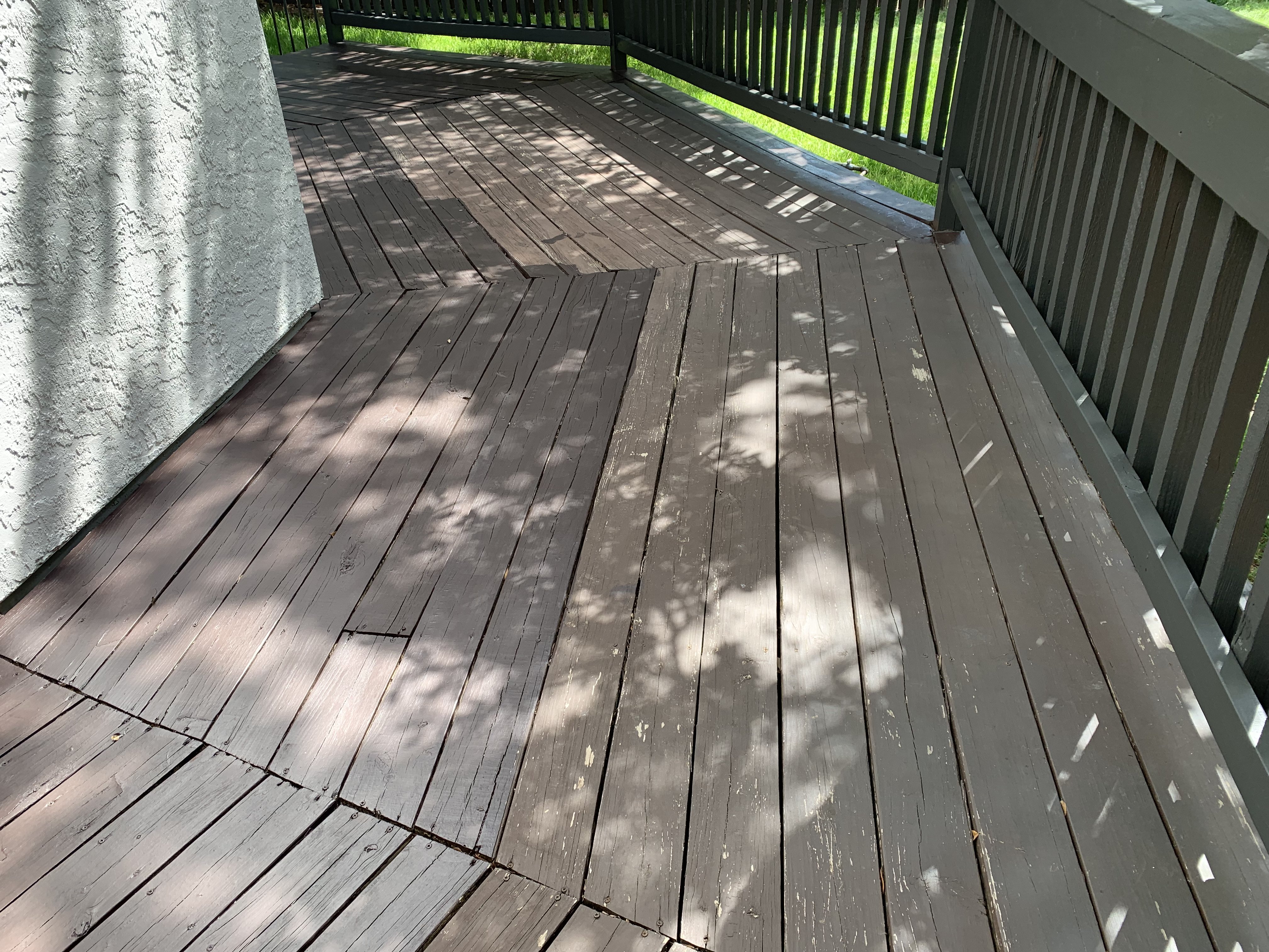 Boerne deck boards before staining — heavy weathering, dirt embedded in the grain, and a rough, splintered surface
