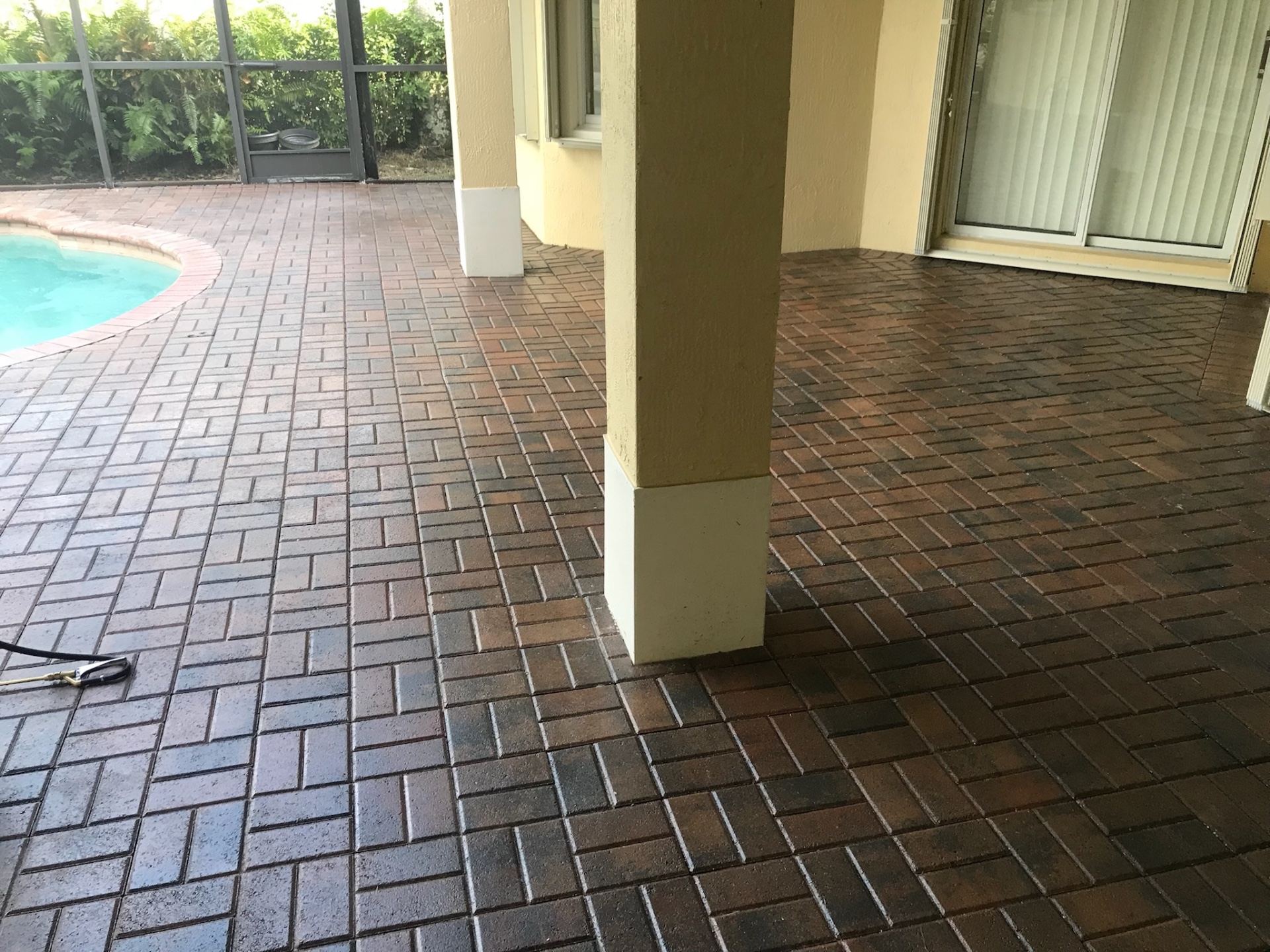 Brick paver pool deck showing the color difference between sealed and unsealed areas