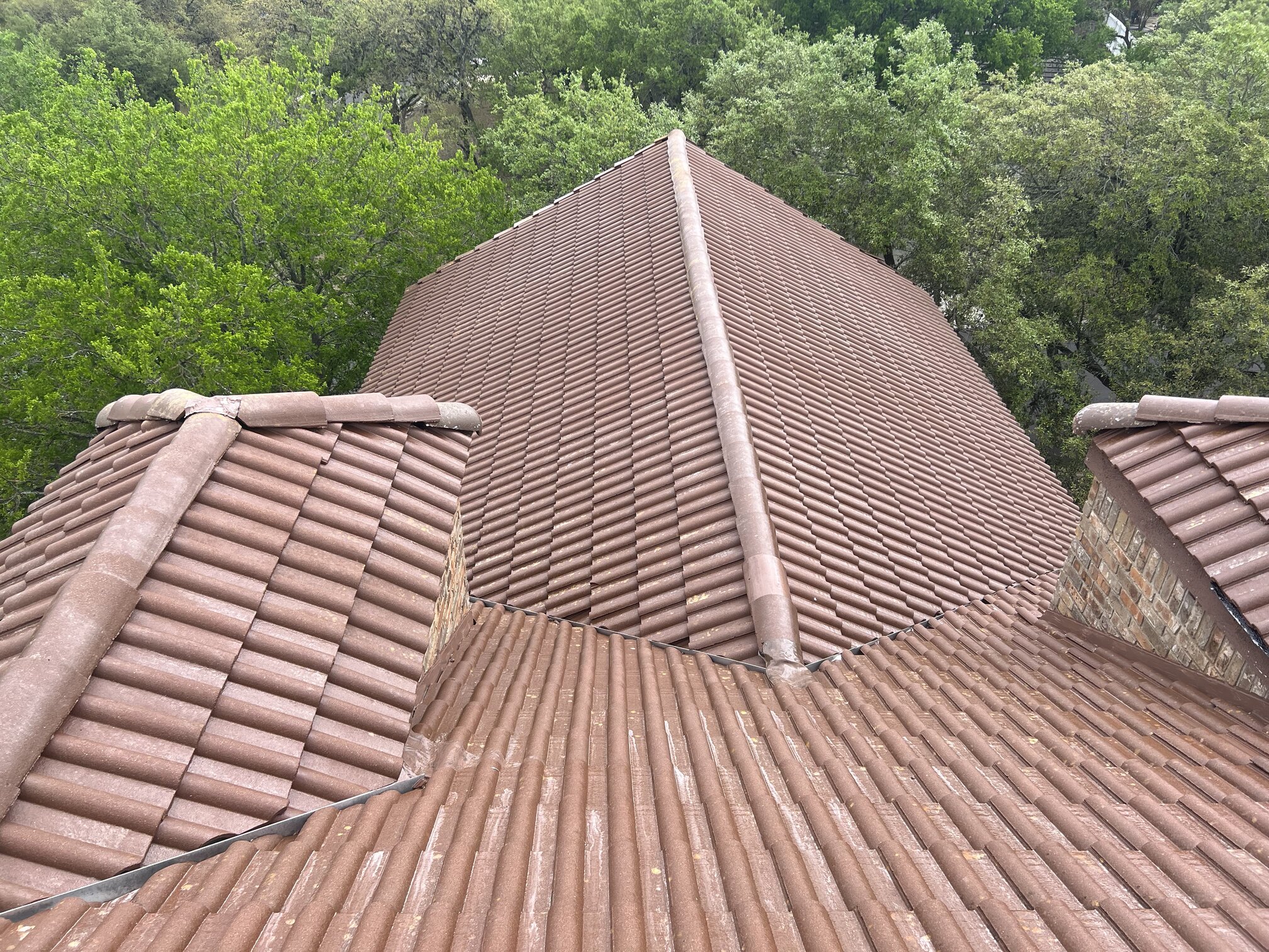 Another Fair Oaks Ranch tile roof before treatment — heavy dark growth across every plane, valley, and ridge