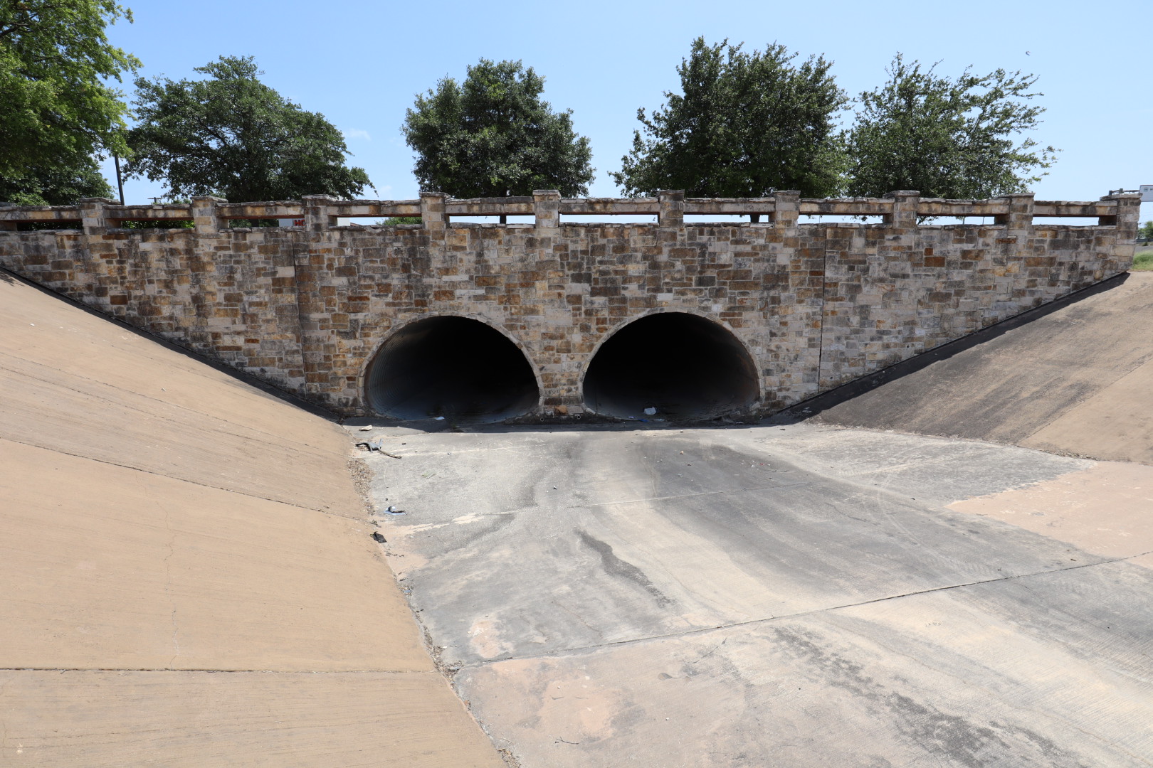 The east bridge at the Rim Shopping Center before cleaning — years of algae, exhaust, and mineral bleed had darkened the stone.