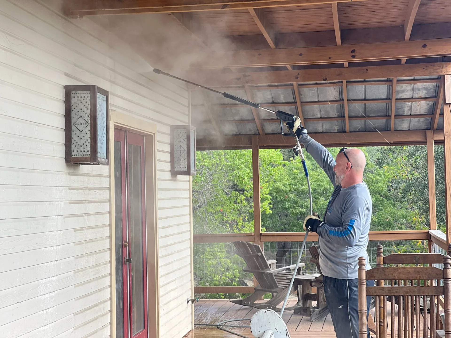Texas Pure Clean technician cleaning a Stone Oak home exterior